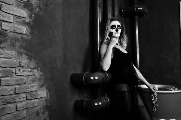 Halloween cráneo maquillaje chica desgaste en negro contra sentarse en re — Foto de Stock