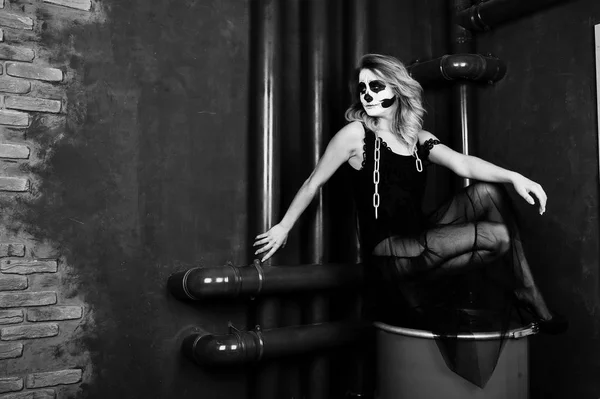Хэллоуин череп макияж девушки носить в черном против сидя на ре — стоковое фото