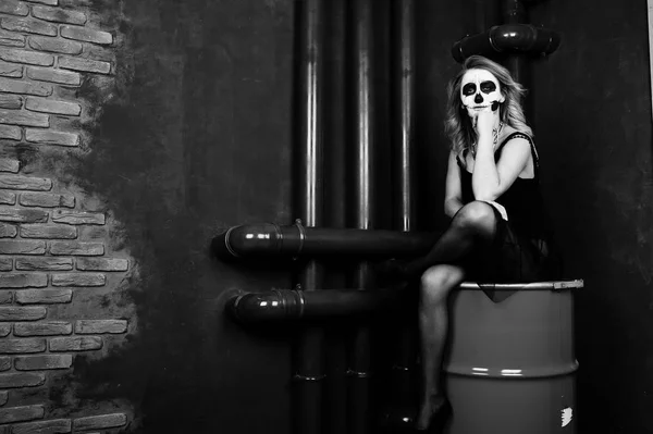 Halloween cranio make up ragazza indossare in nero contro seduto su ri — Foto Stock