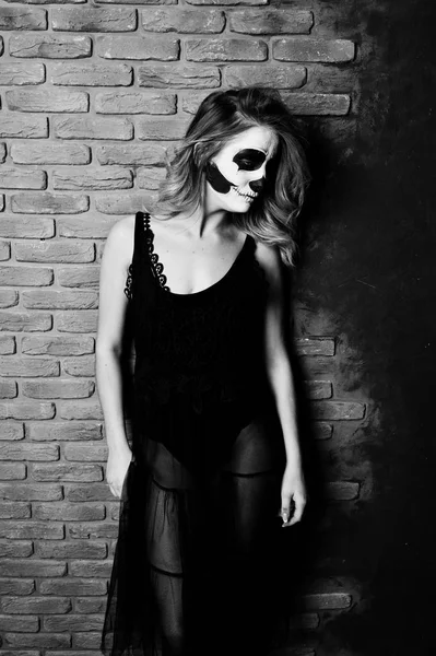 Halloween koponya alkotó lány kopás ellen téglafal, fekete — Stock Fotó