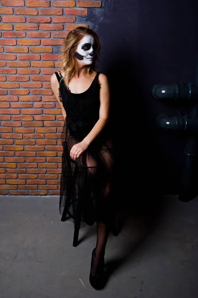 Halloween cranio make up ragazza indossare in nero contro muro di mattoni a — Foto Stock