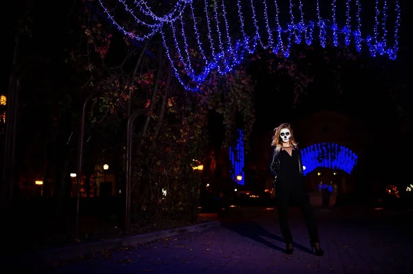 Calavera de Halloween conforman ropa de niña en negro en la calle de noche de ci — Foto de Stock