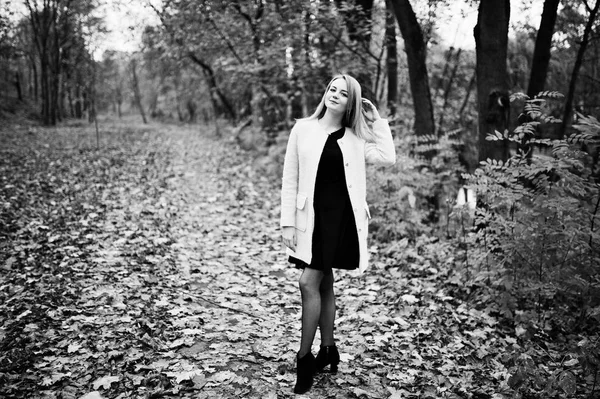 Jeune fille blonde au manteau rose posé sur le parc d'automne . — Photo