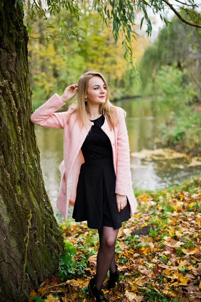 秋天公园里摆着粉红色外套的年轻金发女郎. — 图库照片