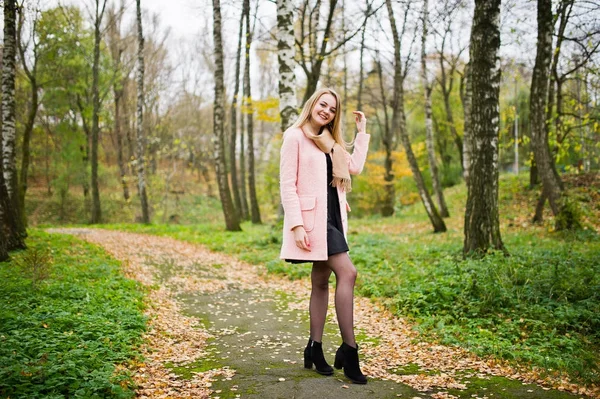 Jeune fille blonde au manteau rose posé sur le parc d'automne . — Photo