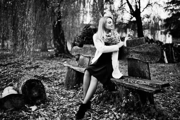 화에 대 한 행 세 하는 벤치에 앉아 핑크 코트에서 젊은 금발 소녀 — 스톡 사진