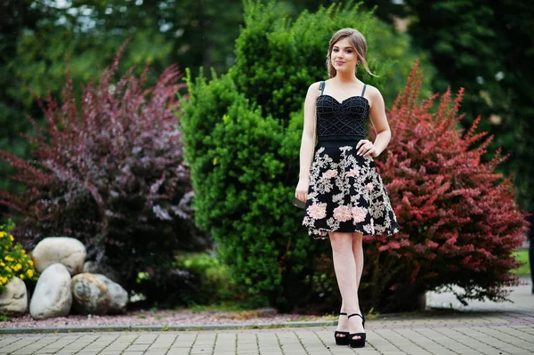 Ritratto di una splendida ragazza in abito floreale nero a piedi — Foto Stock