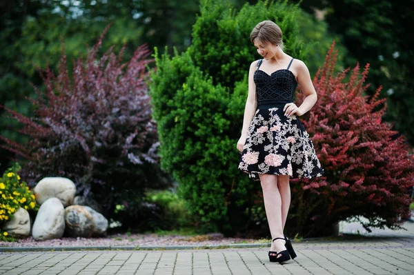 Портрет великолепной молодой девушки в черном цветочном платье ходьба — стоковое фото