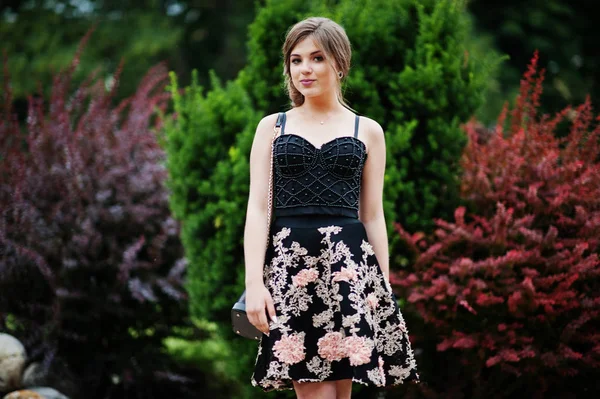 Portret van een prachtig meisje in zwarte bloemen jurk wandelen — Stockfoto