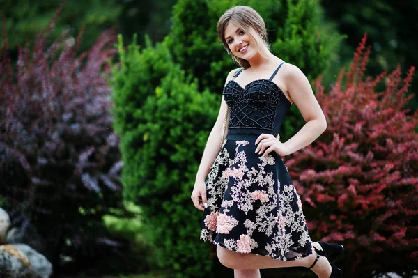 Porträt eines hinreißenden jungen Mädchens im schwarzen floralen Kleid — Stockfoto
