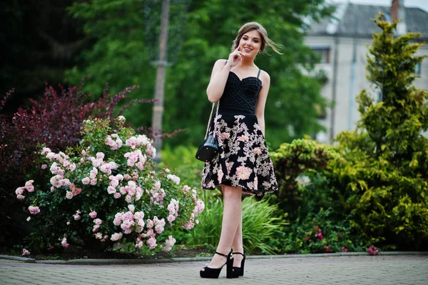 Retrato de uma linda jovem no vestido floral preto andando — Fotografia de Stock