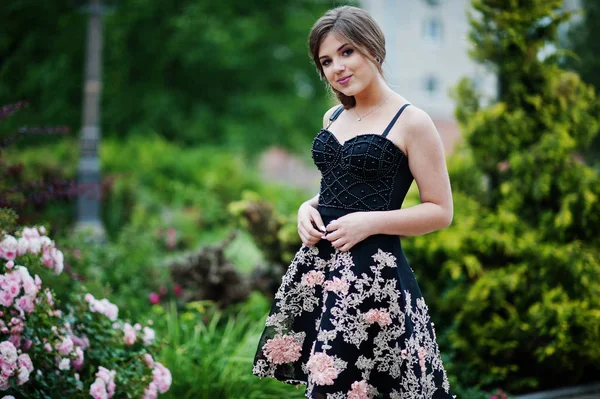 Fekete virágos ruha séta egy gyönyörű fiatal lány portréja — Stock Fotó