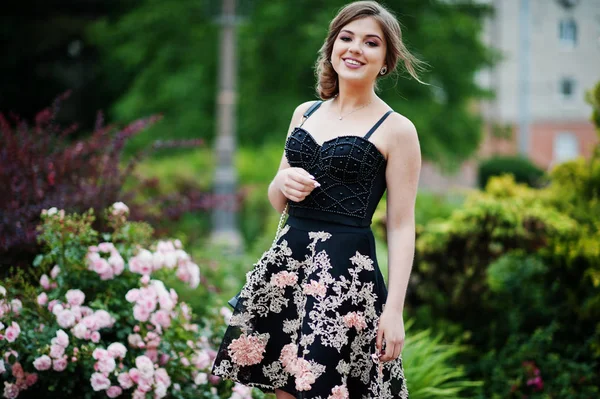 Retrato de una hermosa joven en vestido floral negro caminando —  Fotos de Stock