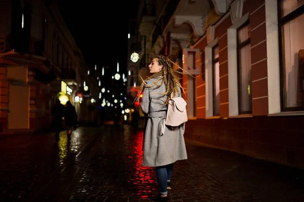 Mädchen mit Dreadlocks zu Fuß in der Nacht Straße der Stadt. — Stockfoto