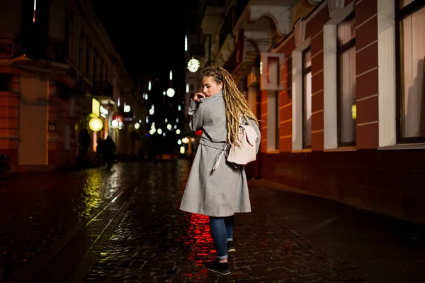 Menina com dreadlocks andando na rua da noite da cidade . — Fotografia de Stock