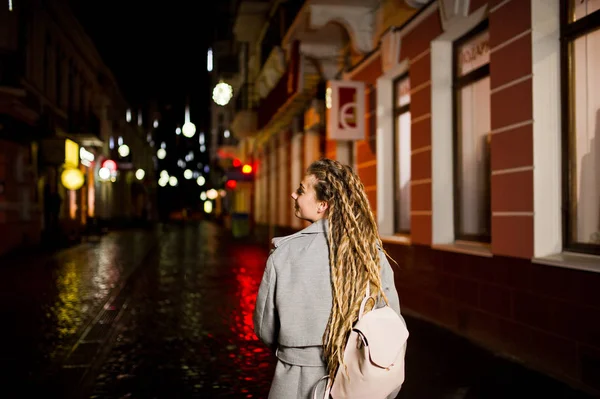 Девушка с дредами гуляет по ночной улице города . — стоковое фото