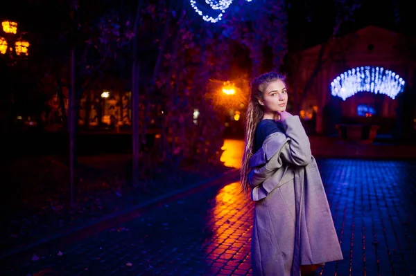 Chica con rastas caminando por la noche calle de la ciudad contra gar —  Fotos de Stock