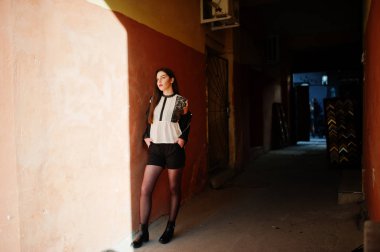 Şık esmer kız Giyim deri ceket ve şort karşı 