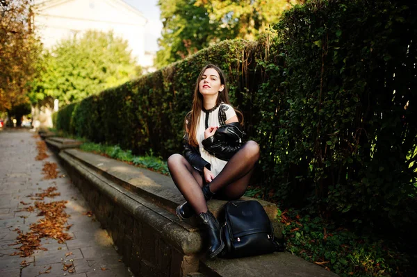 Stylish brunette girl wear on leather jacket and shorts sitting — Stock Photo, Image