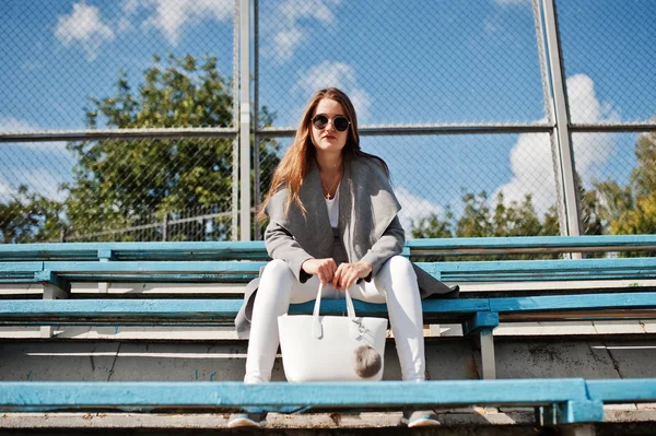 Chica de abrigo gris con gafas de sol en el pequeño estadio de la calle . —  Fotos de Stock