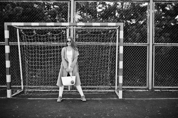 Dziewczyna w szary płaszcz z okulary z małym stadionie ulicy footba — Zdjęcie stockowe