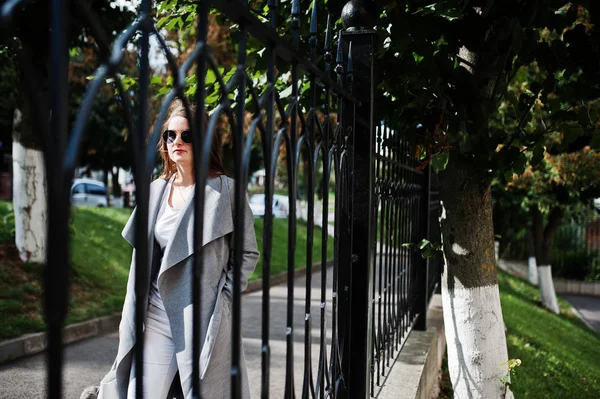 Lány szürke kabátot a napszemüveg és kézitáska, séta utca — Stock Fotó