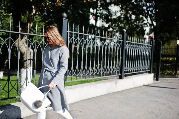 Chica de abrigo gris con gafas de sol y bolso caminando en la calle —  Fotos de Stock