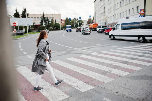 Девушка в сером пальто в солнцезащитных очках и сумочке — стоковое фото