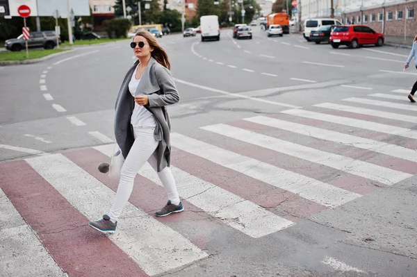 Flicka i grå kappa med solglasögon och handväska gå på ped — Stockfoto