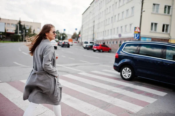 Flicka i grå kappa med solglasögon och handväska gå på ped — Stockfoto