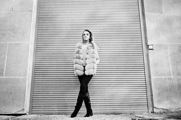 Menina loira em casaco de pele contra parede com persianas . — Fotografia de Stock