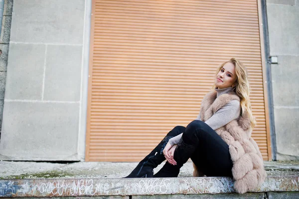 Blonde fille à fourrure manteau contre mur avec volets . — Photo