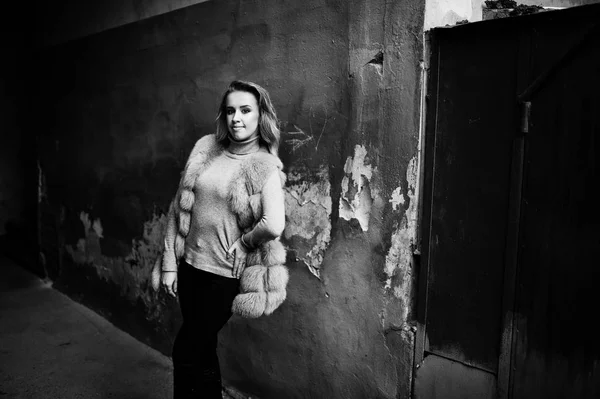 古いオレンジ壁に対して提起の毛皮のコートでブロンドの女の子. — ストック写真