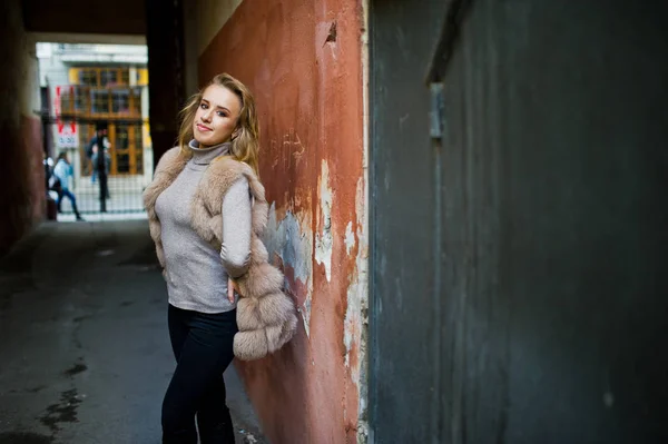 Ragazza bionda a pelliccia posato contro vecchio muro arancione . — Foto Stock