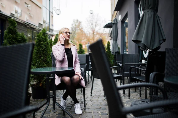 Blondes Mädchen mit Brille und rosa Mantel, schwarzer Tunika am Tab — Stockfoto