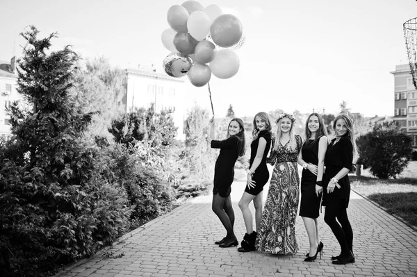 Vijf meisjes dragen op zwart met ballonnen op kip feestje. — Stockfoto