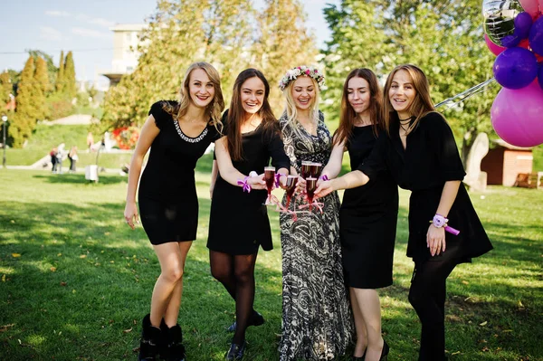 Cinque ragazze indossano su nero con palloncini bere champagne rosso a — Foto Stock
