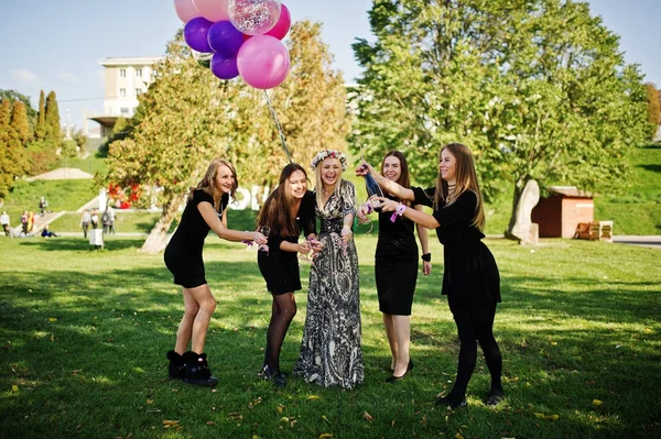 Πέντε κορίτσια φοράνε τη μαύρη με μπαλόνια πίνοντας κόκκινο σαμπάνιας στο — Φωτογραφία Αρχείου