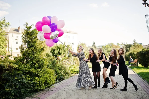 Cinco chicas se visten de negro con globos en despedida de soltera . — Foto de Stock