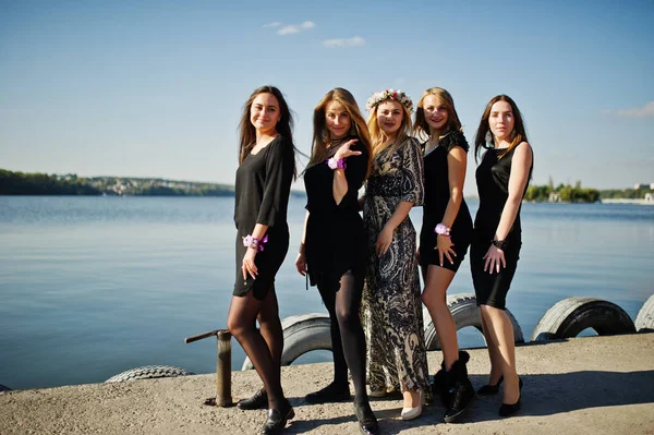 Fünf Mädchen in Schwarz amüsieren sich auf Junggesellenabschied am See. — Stockfoto