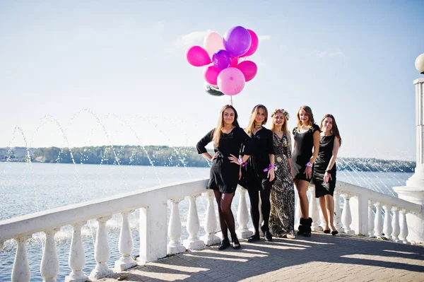 Cinque ragazze indossano su nero camminare con palloncini al partito di addio al nubilato agai — Foto Stock