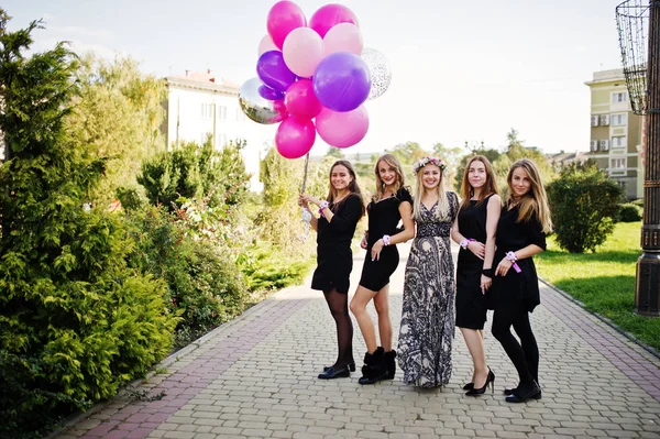 Fünf Mädchen tragen auf Junggesellenabschied schwarz mit Luftballons. — Stockfoto