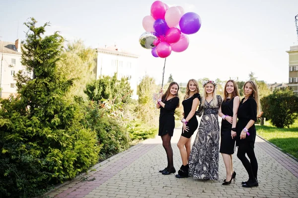 Fünf Mädchen tragen auf Junggesellenabschied schwarz mit Luftballons. — Stockfoto