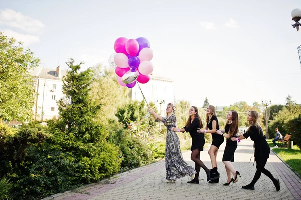 Vijf meisjes dragen op zwart met ballonnen op kip feestje. — Stockfoto