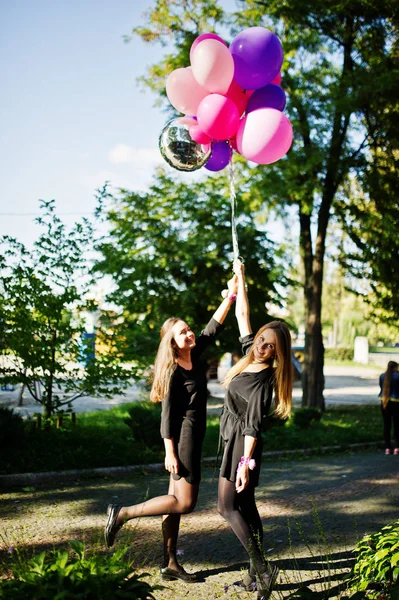 Δύο κορίτσια φορούν μαύρο, με μπαλόνια στο κότα κόμμα. — Φωτογραφία Αρχείου