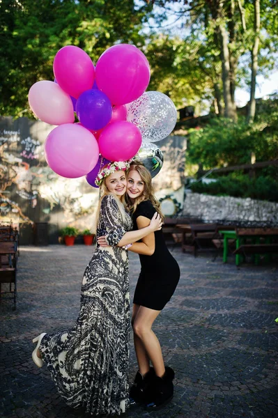 Dvě dívky nosí na černém pozadí s bublinami v hen party. — Stock fotografie
