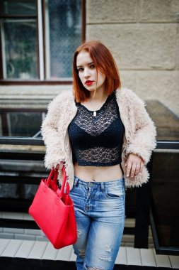 Kırmızı saçlı kız kırmızı el çantası ile şehir Caddesi'nde poz verdi..