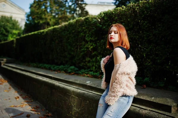 Fille aux cheveux rouges posée à la rue ensoleillée de la ville . — Photo