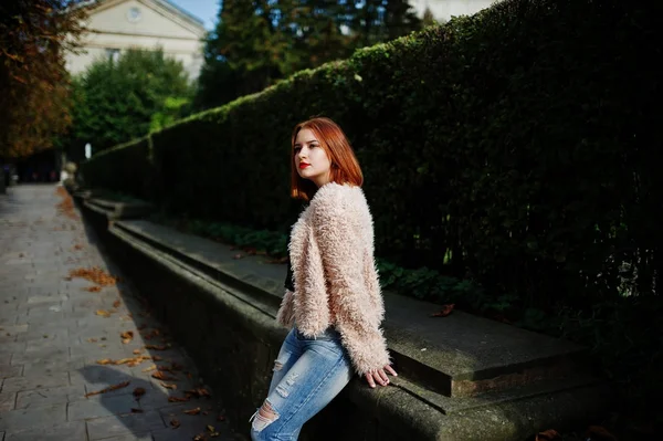 Fille aux cheveux rouges posée à la rue ensoleillée de la ville . — Photo