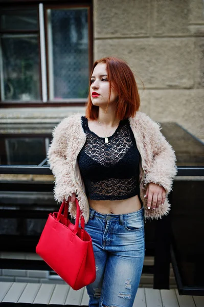 Chica pelirroja con bolso rojo posado en la calle de la ciudad . — Foto de Stock